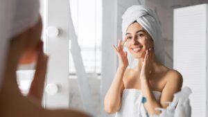 Woman Applying Eye Cream Taking Care Of Skin In Bathroom