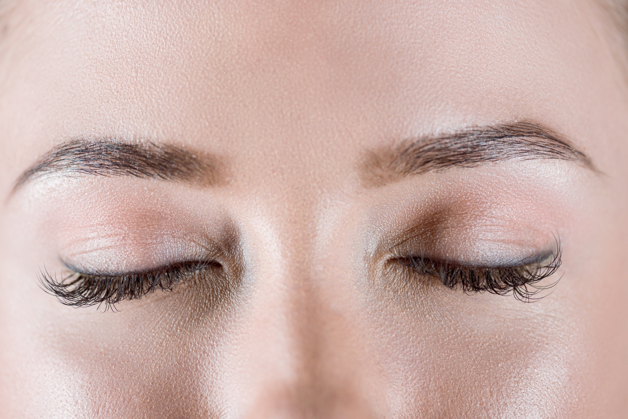 Close-up view of closed female eyes with long eyelashes
